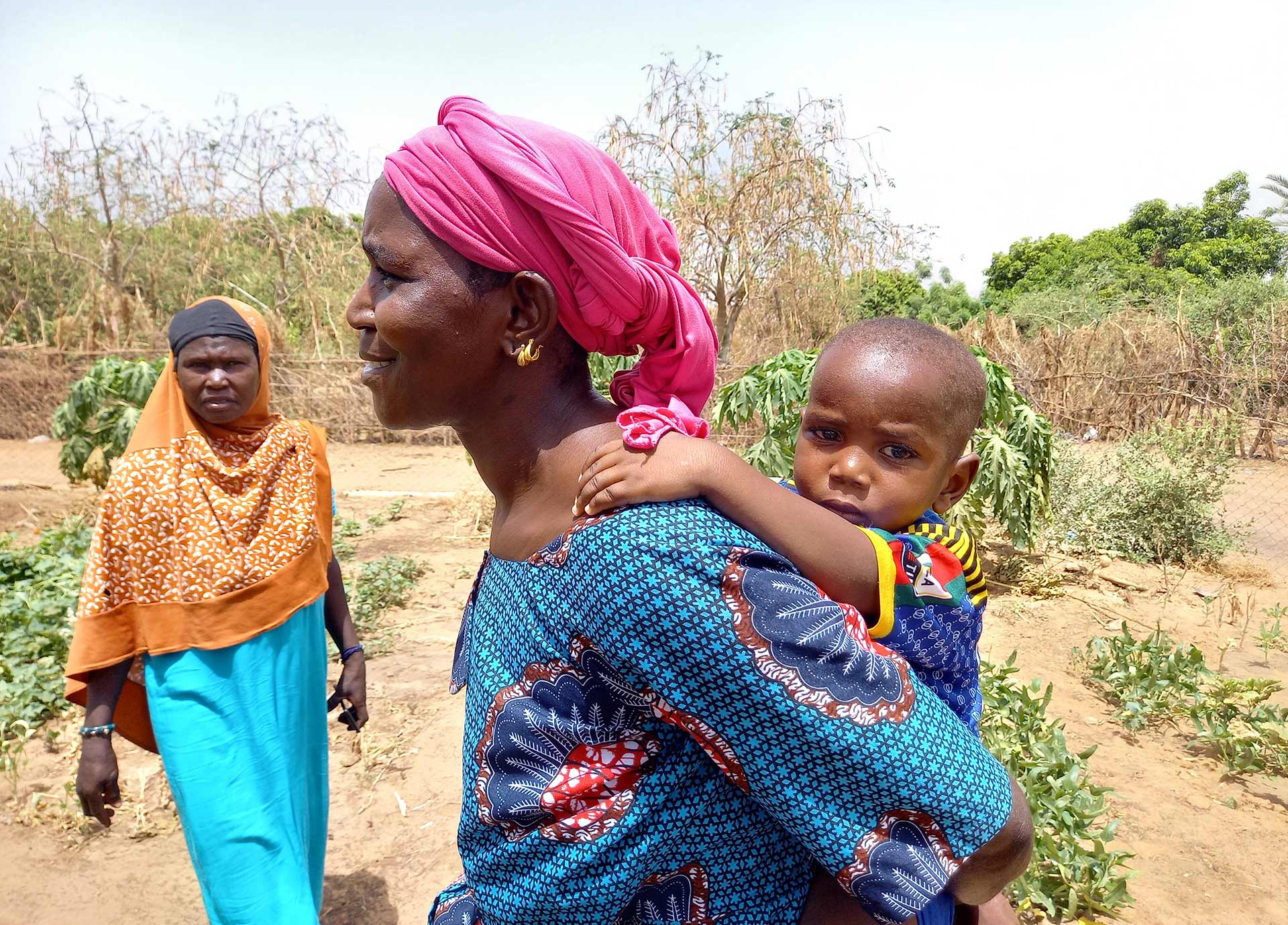 Eine Frau mit ihrem Baby auf dem Rücken.