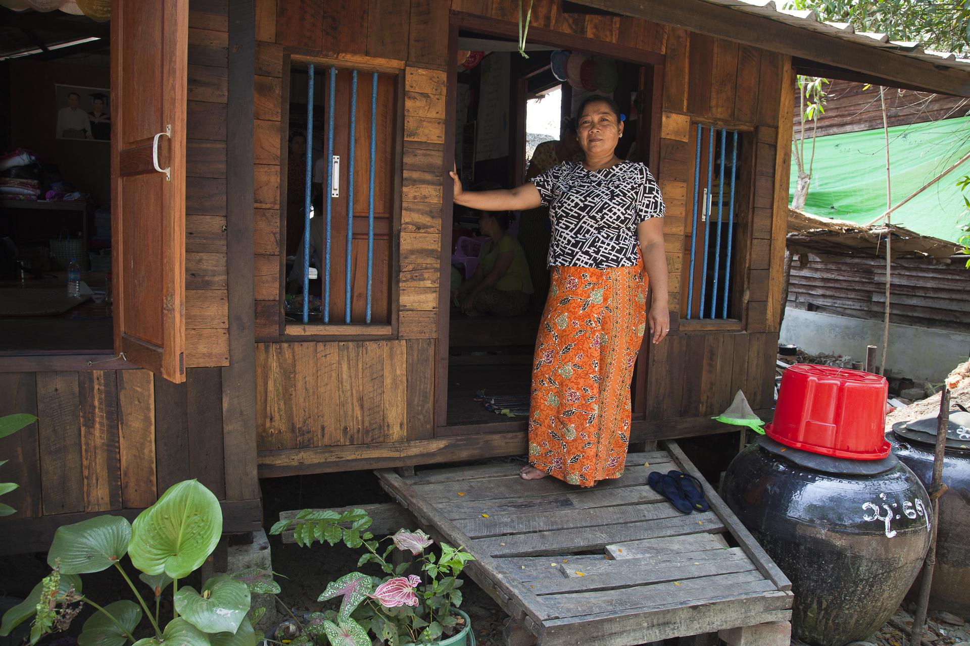 Frau steht vor Hütte