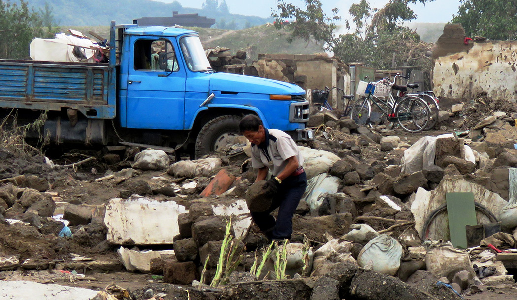 Ein Mann räumt Trümmer auf