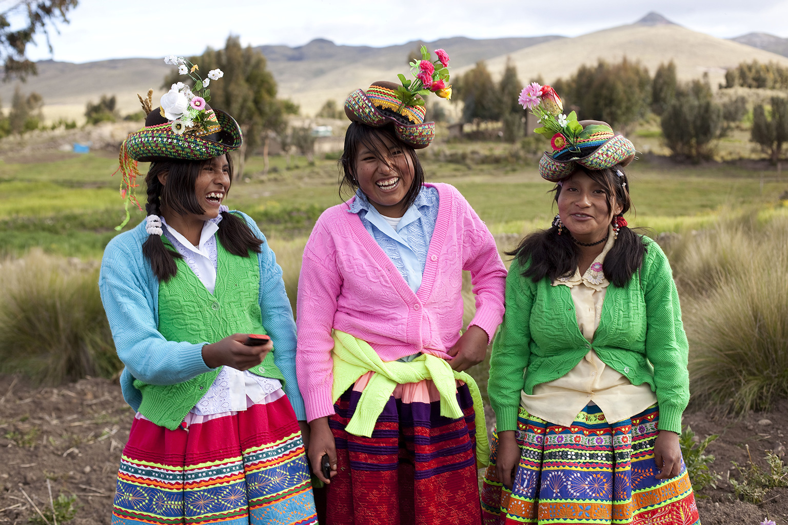 Drei junge Frauen in peruanischer Tracht bei der Gemeinschaftsarbeit