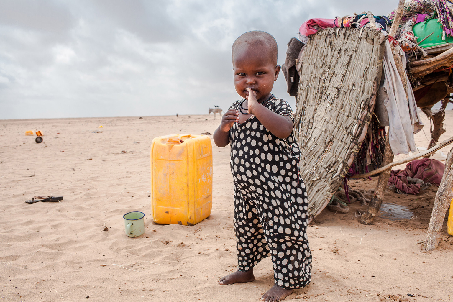 Ein Kleinkind steht während der extremen Dürreperiode, die 2017 Somaliland heimsuchte, vor einem Zelt in der Wüste.
