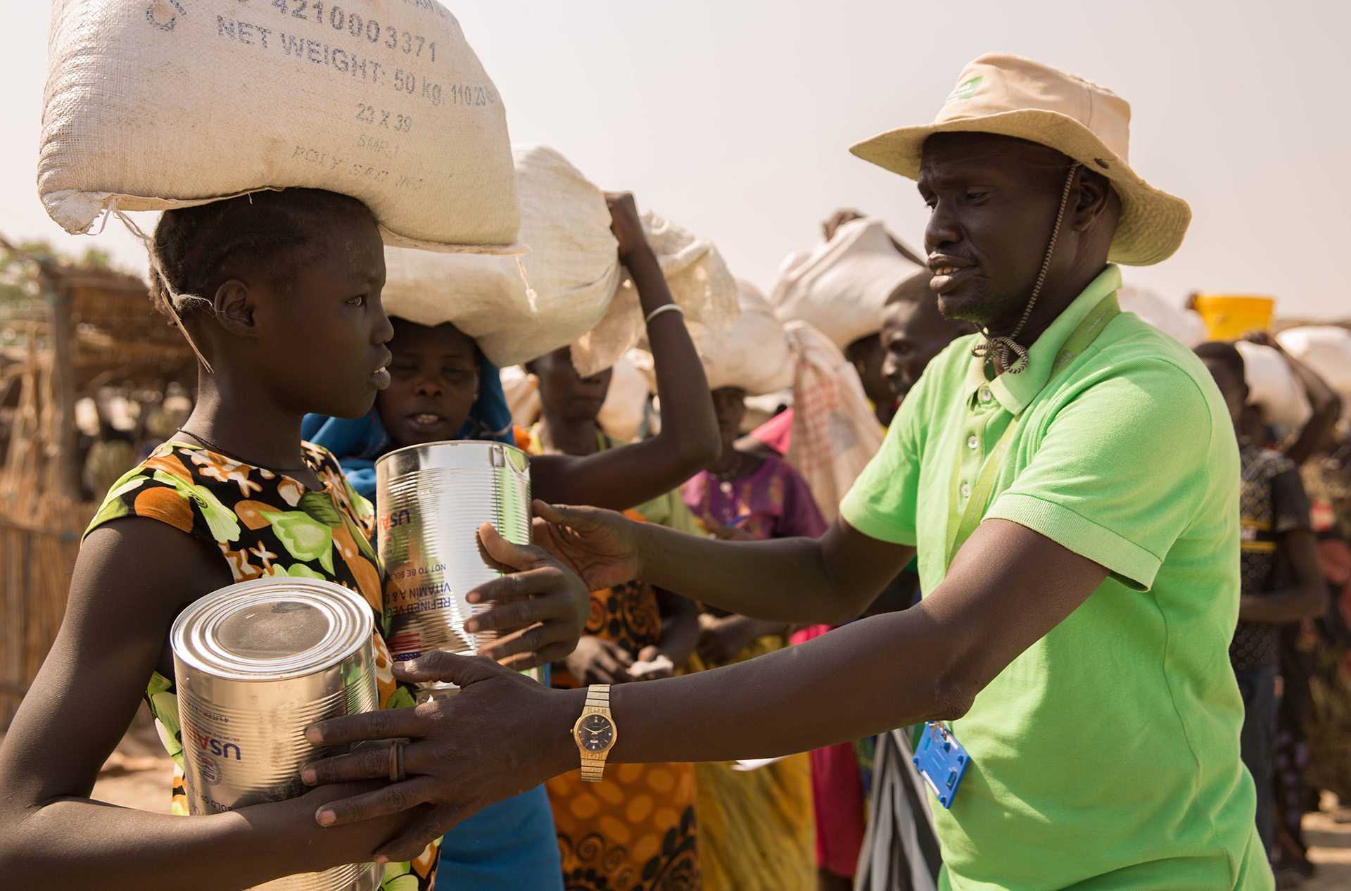 Ein Mitarbeiter der Welthungerhilfe reicht einer Frau im Flüchtlingscamp Bentiu Hilfsgüter