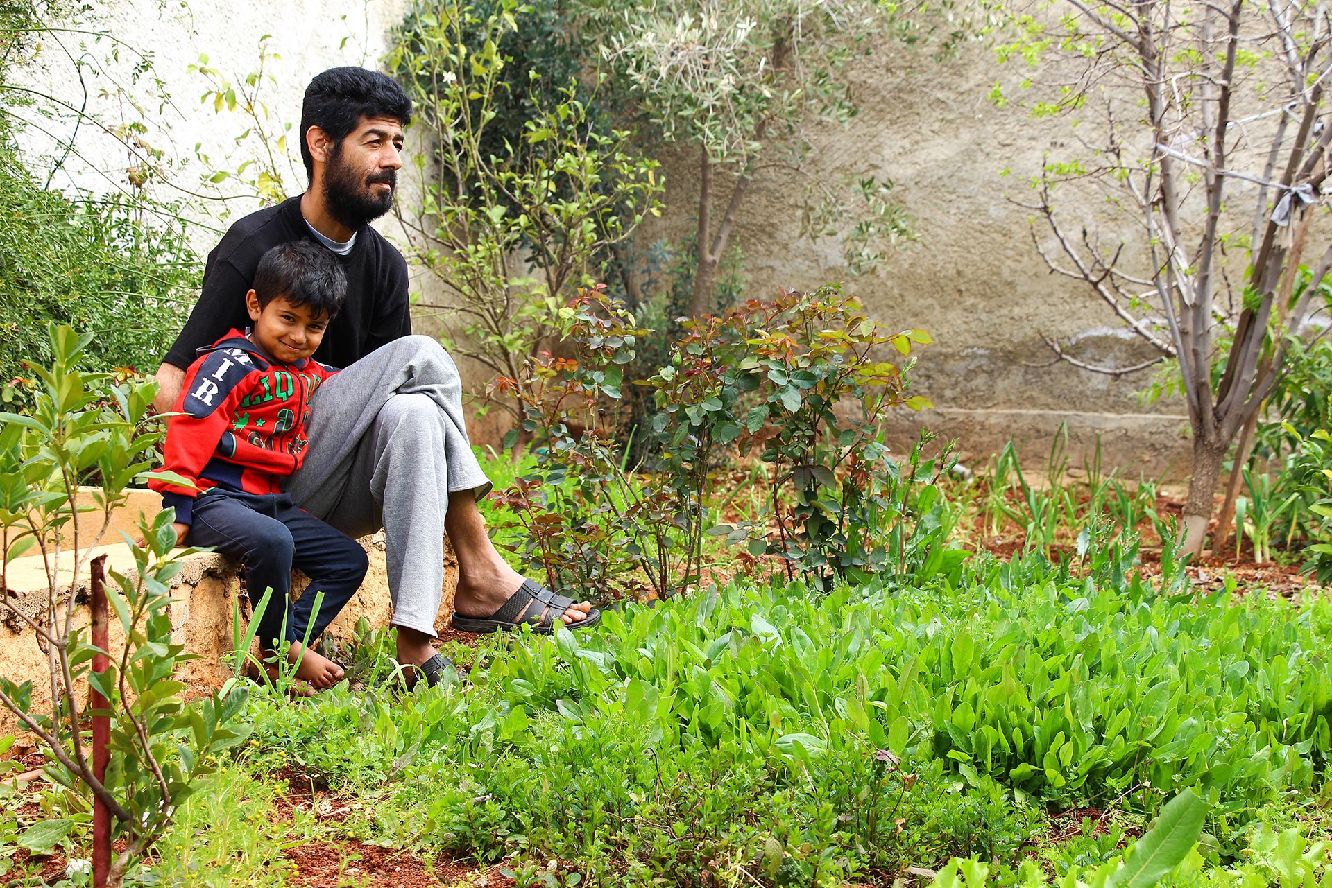 Obeida Yousef mit seinem Sohn im Gemüsegarten