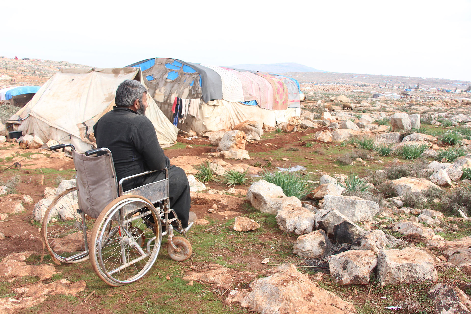Ein Mann im Rollstuhl in einem Flüchtlingscamp