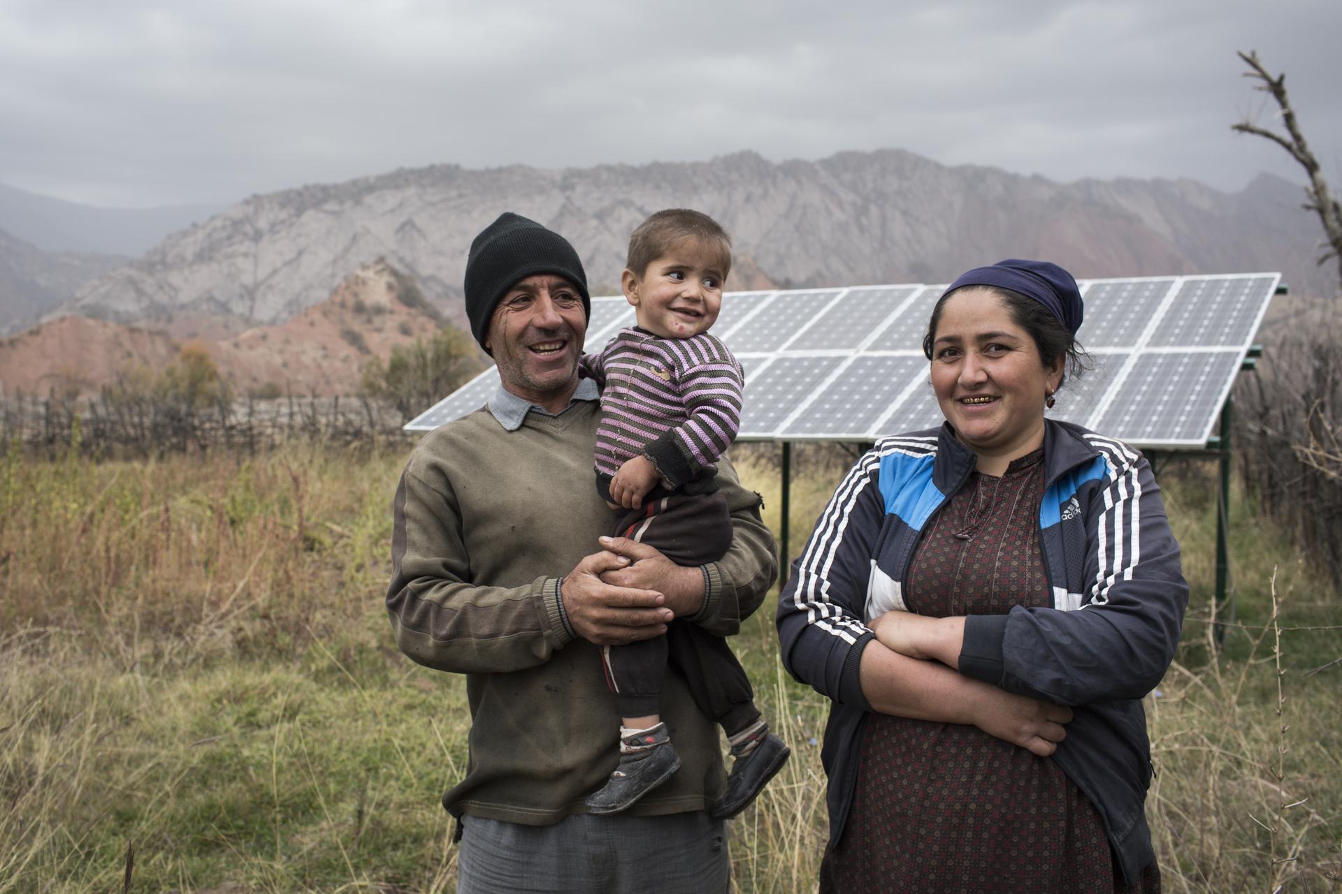 Eine Familie vor ihrer Solaranlage in Tadschikistan.