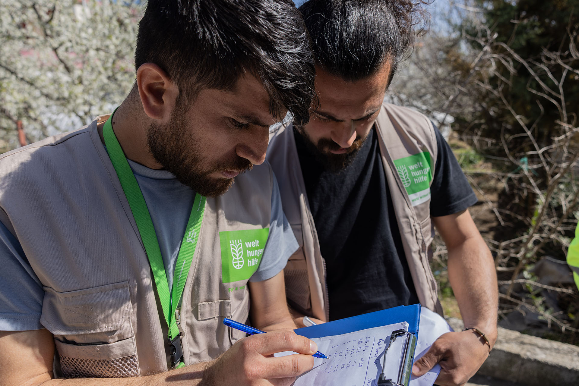 Zwei Männer prüfen eine Liste auf einem Klemmbrett. Vorausschauendes humanitäres Handeln ist mit viel Planung verbunden.