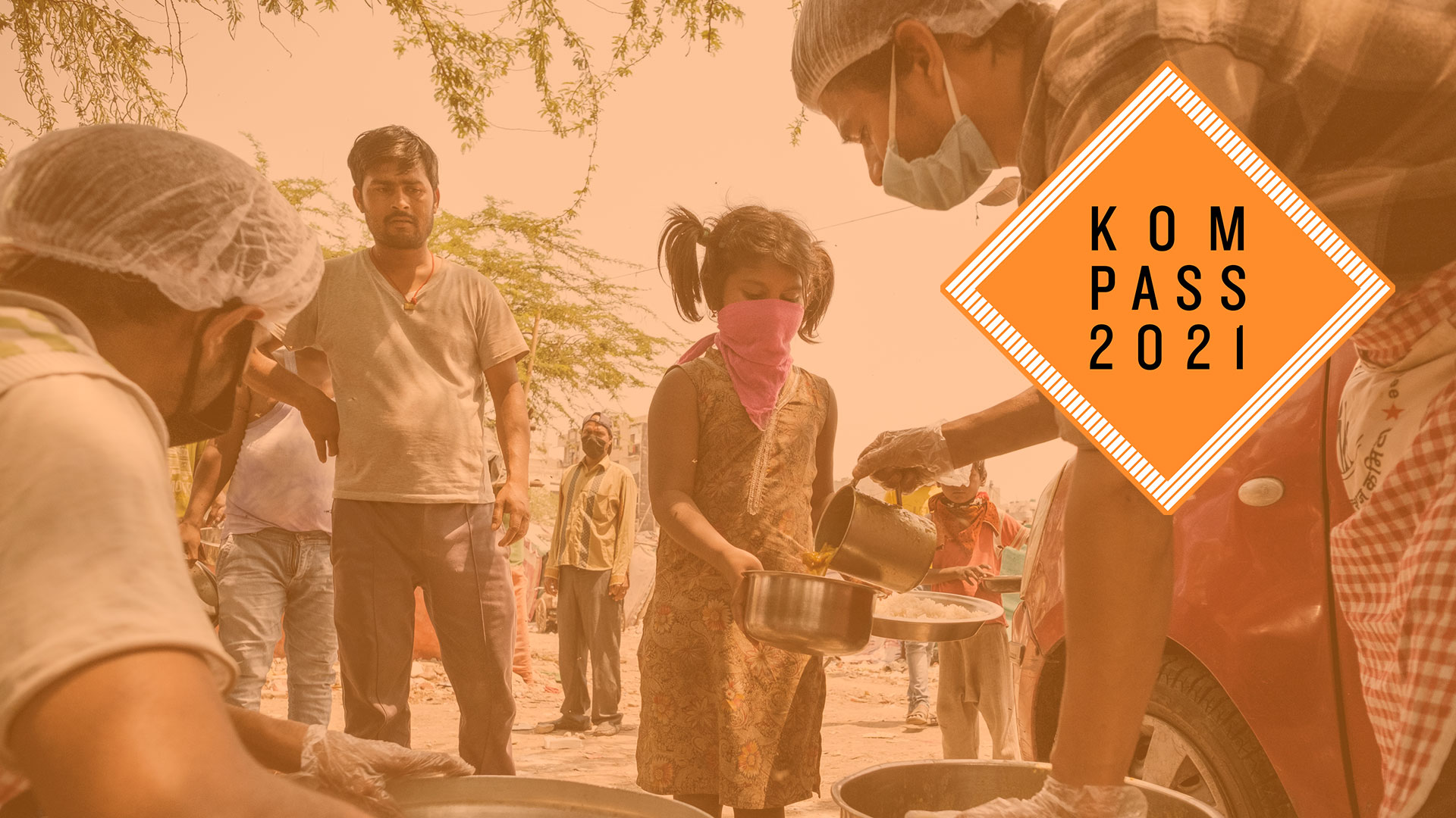 2020-kompass-corona-essensverteilung-nothilfe-indien-logo_C_lang.jpg Corona-Krise in Indien. Ein Mädchen mit Mund-Nase-Schutz hält einen Teller und einen Topf, in welchen ein Mann Essen füllt. Oben rechts ist das Kompass 2021 Logo.