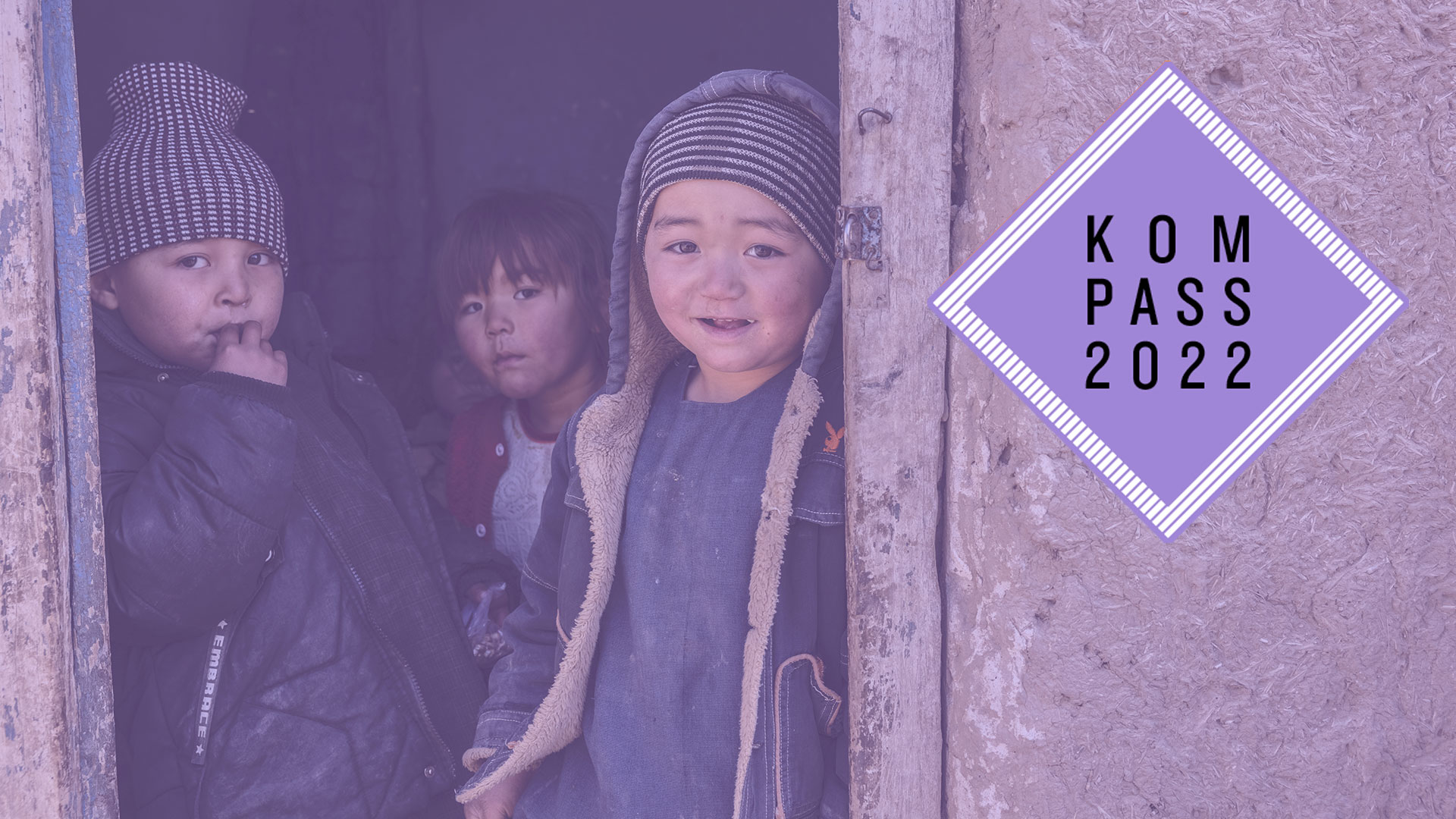 2022-kompass-kinder-nothilfe-afghanistan-logo_C_glinski.jpg Drei Kinder in Afghanistan stehen in einer Tür und schauen Richtung Kamera. Rechts oben liegt eine Grafik über dem Foto mit dem violetten Logo des Kompass 2022.